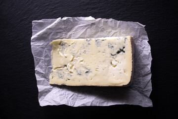 slice of Gorgonzola cheese on a black background. Typical Italian cheese from the Piedmont region