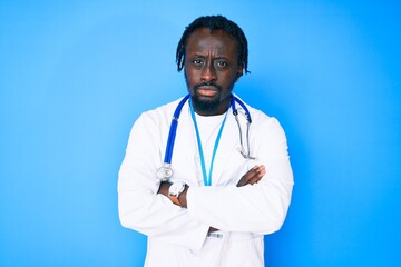 Young african american man with braids wearing doctor stethoscope and id pass skeptic and nervous, disapproving expression on face with crossed arms. negative person.