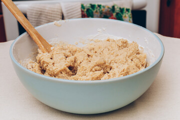 Process of kneading gingerbread dough using wooden scapula.