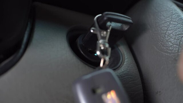 The driver inserts the ignition key into the ignition lock, turns it and starts the engine, then turns off the engine and takes out the key. Close up