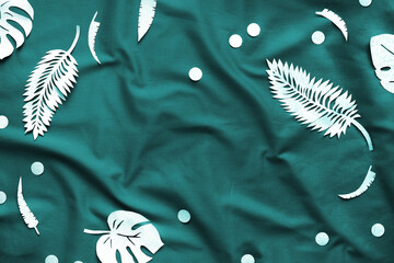 Tidewater green color. Creative trendy flat lay with exotic paper leaves, monstera and fern on textile background. Top view. Monochrome flat lay. Minimal creative concept with copy-space.