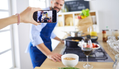 Portrait of handsome man filming cooking show or blog