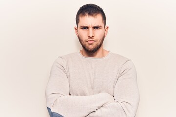 Fototapeta premium Young handsome man wearing casual sweater skeptic and nervous, disapproving expression on face with crossed arms. negative person.