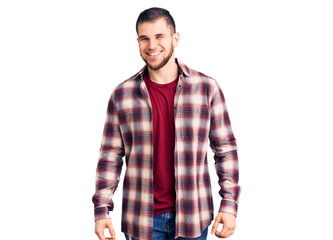 Young handsome man wearing casual shirt winking looking at the camera with sexy expression,...