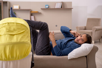 Young male contractor looking after baby at home