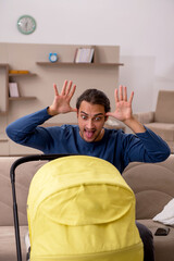 Young male contractor looking after baby at home