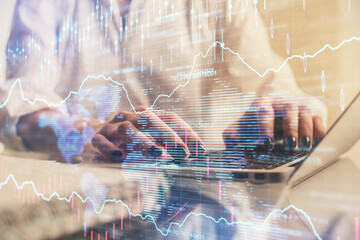 Double exposure of woman hands typing on computer and forex chart hologram drawing. Stock market...