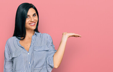 Young caucasian woman wearing casual clothes smiling cheerful presenting and pointing with palm of hand looking at the camera.