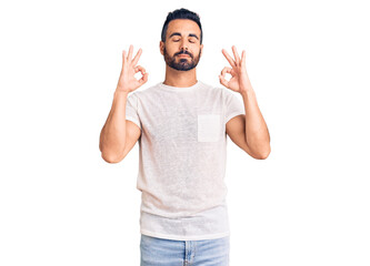 Fototapeta premium Young hispanic man wearing casual clothes relax and smiling with eyes closed doing meditation gesture with fingers. yoga concept.