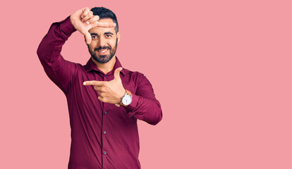 Young hispanic man wearing casual clothes smiling making frame with hands and fingers with happy face. creativity and photography concept.