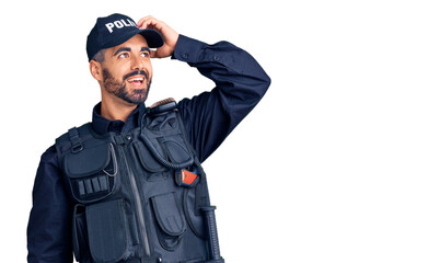 Young hispanic man wearing police uniform smiling confident touching hair with hand up gesture, posing attractive and fashionable