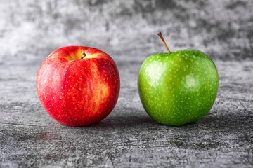Green and red apples on blackboard or chalkboard background. Bright fruit composition. Close-up on a gray background.