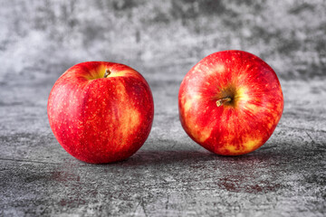 Green and red apples on blackboard or chalkboard background. Bright fruit composition. Close-up on a gray background.