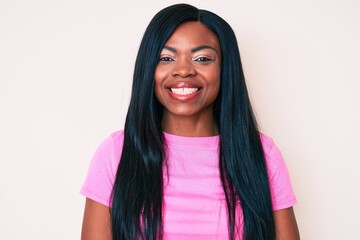 Young african american woman wearing casual clothes looking positive and happy standing and smiling with a confident smile showing teeth