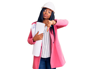 Young african american woman wearing architect hardhat holding blueprints with angry face, negative...