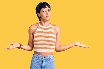 Young brunette woman with short hair wearing casual clothes clueless and confused with open arms, no idea concept.