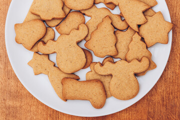 Tasty Christmas gingerbread cookies on the white plate.