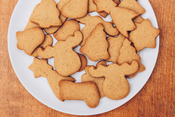 Tasty Christmas gingerbread cookies on the white plate.