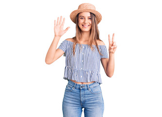 Obraz na płótnie Canvas Young beautiful girl wearing hat and t shirt showing and pointing up with fingers number seven while smiling confident and happy.