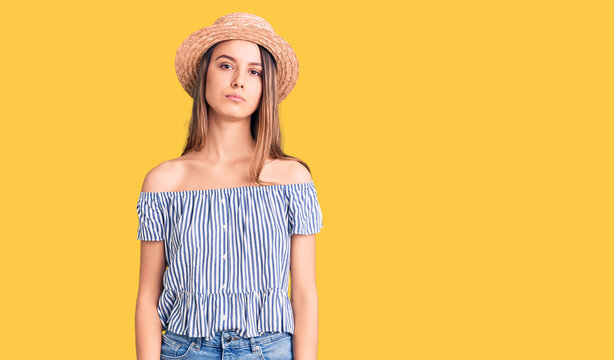 Young beautiful girl wearing hat and t shirt relaxed with serious expression on face. simple and natural looking at the camera.