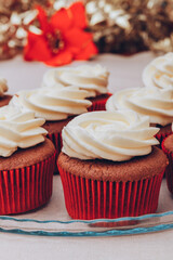 Delicious chocolate cupcakes with swirled frosting cream on top. Cupcakes on a glass tray with colorful holiday background.