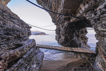 Wooden bridge, part of footpath fort tourist from Old Town to small bay with Mogren Beach in Budva, Montenegro