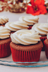 Delicious chocolate cupcakes with swirled frosting cream on top. Cupcakes on a glass tray with colorful holiday background.