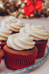 Delicious chocolate cupcakes with swirled frosting cream on top. Cupcakes on a glass tray with colorful holiday background.