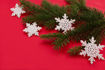 Spruce and snowflakes on a red background.