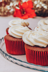 Delicious chocolate cupcakes with swirled frosting cream on top. Cupcakes on a glass tray with colorful holiday background.
