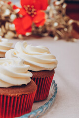 Delicious chocolate cupcakes with swirled frosting cream on top. Cupcakes on a glass tray with colorful holiday background.