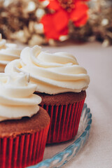 Delicious chocolate cupcakes with swirled frosting cream on top. Cupcakes on a glass tray with colorful holiday background.