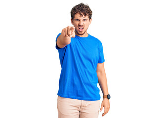 Young handsome man with curly hair wearing casual clothes pointing displeased and frustrated to the camera, angry and furious with you