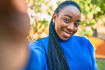 Young african american woman smiling happy making selfie by the camera at the park.