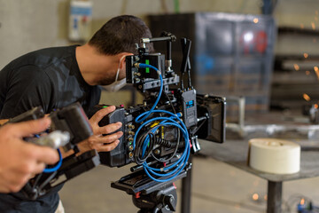 Obraz na płótnie Canvas Camarógrafo con cámara de cine digital en taller industrial de siderurgia
