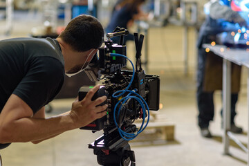 Camarógrafo con cámara de cine digital en taller industrial de siderurgia
