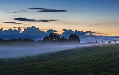 Obraz premium Fog rising over fields near Jeziorowskie village, Masuria region of Poland