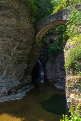 Fototapeta na wymiar Natural water pool with stone bridge on top