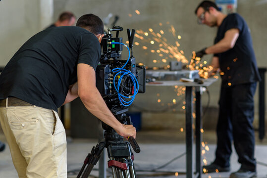Camarógrafo con cámara de cine digital en taller industrial de siderurgia