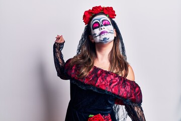 Young woman wearing day of the dead costume over white stretching back, tired and relaxed, sleepy and yawning for early morning