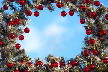 decorative frame from a decorated christmas tree on a blue sky background