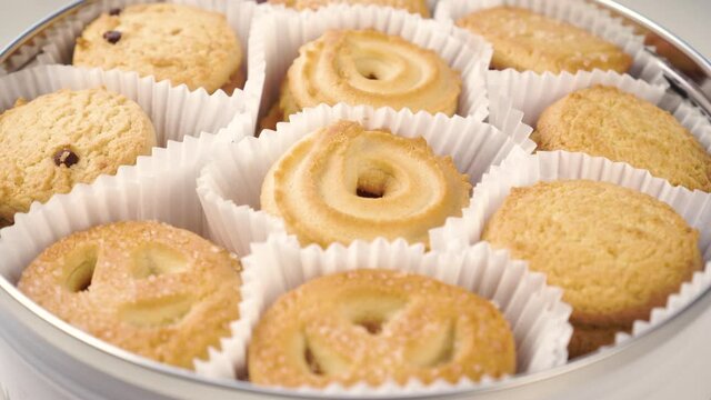 English butter biscuits in paper packaging in a steel box closeup. Rotation