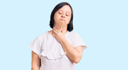 Brunette woman with down syndrome wearing casual white tshirt touching painful neck, sore throat for flu, clod and infection