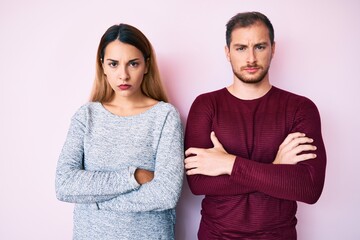 Beautiful couple wearing casual clothes skeptic and nervous, disapproving expression on face with crossed arms. negative person.