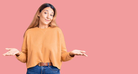 Beautiful young woman wearing casual clothes clueless and confused expression with arms and hands raised. doubt concept.