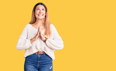 Beautiful young woman wearing casual clothes begging and praying with hands together with hope expression on face very emotional and worried. begging.