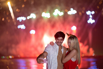 Young couple enjoy firework during celebration festival on the beach.