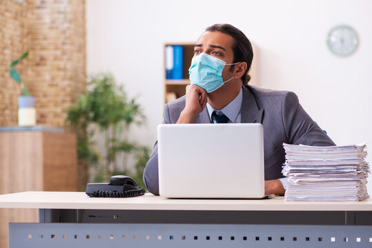 Young male employee wearing mask during pandemic - Powered by Adobe