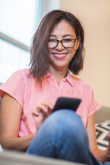 Obraz premium Portrait of a mature Asian woman texting on the phone.