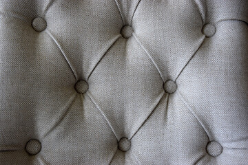 Close up detail of a luxury upholstered hotel chair with buttons and pleated fabric